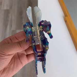 Detail view of double seahorse acetate hair claw clip with colorful marble texture pattern