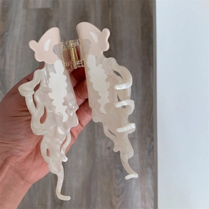 Detail of large cream jellyfish hair claw clip with marble texture and strong spring