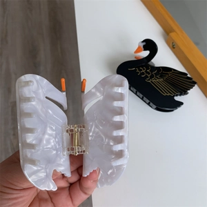 Close-up of elegant white marble pattern acetate butterfly hair claw with metal spring