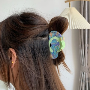 Close-up of creative flip-flop shaped acetate hair claw clip with colorful marble pattern