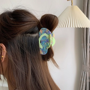 Detail of creative flip-flop acetate hair claw with colorful marble texture and crystals