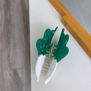 Detail view of butterfly hair claw clip with green marble acetate and sturdy gold spring