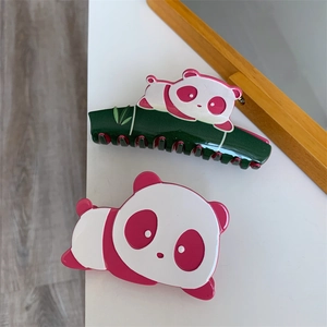 Detail showing two cute panda hair claws made of glossy acetate in green and pink colors