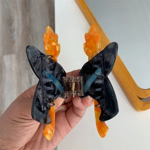 Pince à cheveux papillon d'Halloween avec ailes marbrées noires et détails de flammes