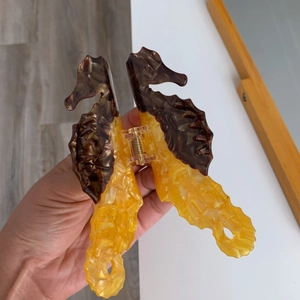 Detail of amber and brown seahorse hair claw clip made of acetate with metal spring