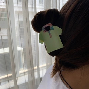 Detail view of a creative green polo shirt shaped acetate hair claw clip worn on hair