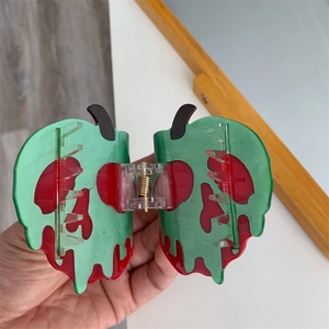 Détail d'une pince à cheveux créative en acétate au design de crâne de pomme empoisonnée