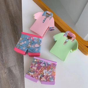 Detail of creative acetate hair claws in polo shirt and shorts shapes with rhinestone accents