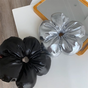 Chouchous fleurs en simili cuir aux finitions argent métallisé et noir brillant