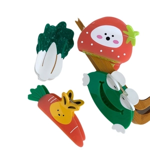 Cute acetate hair claws in strawberry, frog, carrot, and cabbage designs on white background