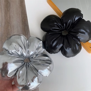 Détail de chouchous fleurs en cuir argent et noir avec éclat métallique et rembourrage