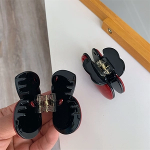 Detail of red and black flower hair claws with a strong gold metal spring for hair styling