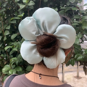 Detail view of large mint green satin floral scrunchie with padded 3D cotton petals