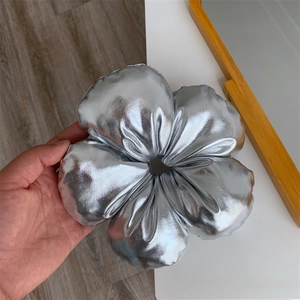 Vue macro du chouchou fleur en cuir synthétique argenté avec un éclat métallique