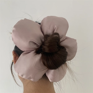 Back view of oversized dusty pink 3D flower scrunchie styled on a bun hairstyle