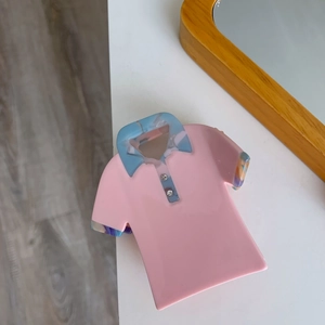 Detail of pink polo shirt shaped acetate hair claw clip with blue marble collar and crystals