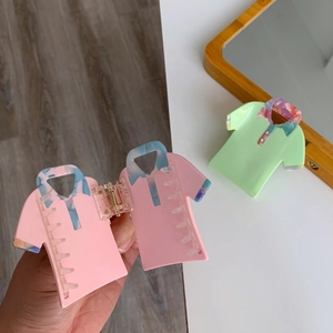 Detailed view of creative shirt-shaped acetate hair claws in pink and green colors