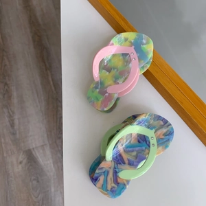 Detailed view of creative acetate flip-flop hair clips with marbled textures and tiny rhinestones