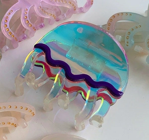 Dettaglio macro della molletta per capelli a forma di medusa in acetato olografico