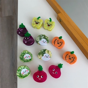 Detalle de pinzas para el pelo con formas de verduras coloridas como calabaza y rábano