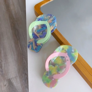 Close-up of acetic acid hair clips in creative flip-flop shape with marble texture