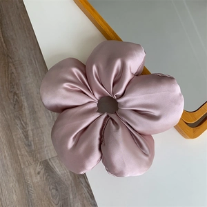 Macro view of the dusty pink satin fabric five-petal flower scrunchie accessory