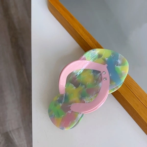 Macro shot of flip-flop shaped hair claw made of colorful marble acetate material