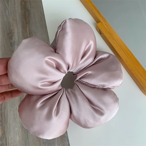 Macro shot of 15cm oversized lotus pink flower scrunchie made of soft satin fabric