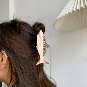 Detail of creative shark-shaped hair claw made of acetate in cream and tortoiseshell colors