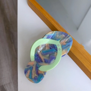 Detailed macro view of creative acetate slipper-shaped hair clip with colorful marble pattern