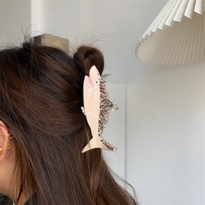 Detail view of a creative shark hair claw clip in acetate finish on a half-up hairstyle
