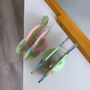 Detail view of marble acetate hair claws with colorful translucent texture and spring