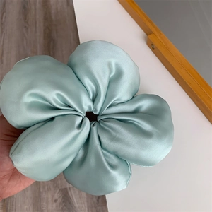 Detail of mint green satin oversized flower scrunchie with 3D pleated petals