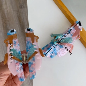 Detail view of large grasshopper acetate hair claw clips showing premium marble textures