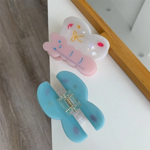 Detalle de pinzas para el cabello de mariposa en acetato rosa y azul con estampados