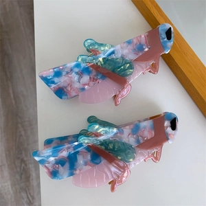 Creative insect-shaped hair claws made of colorful marbled acetate in pink and blue tones