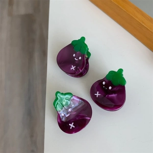 Vista detallada de tres pinzas para el cabello de berenjena en acetato morado