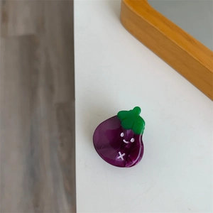 Vista detallada de la pinza de pelo berenjena púrpura con diseño de cara sonriente
