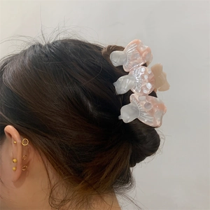 Pinze per capelli a fungo creative e orecchini a bottone dorati su una modella