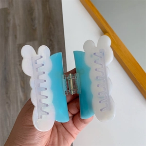 Detalle de la pinza de pelo en acetato azul y blanco con perfil de oso y resorte metálico