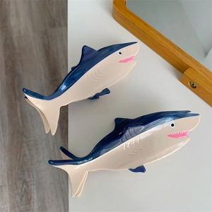 Close-up of two ocean series shark hair clips in blue and beige acetate color block
