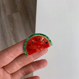 Détail macro d'une pince à cheveux pastèque mignonne montrant la texture acrylique polie