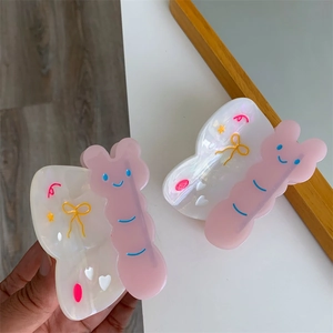 Vista detallada de pinzas para el pelo de mariposa con motivos de corazones y caras