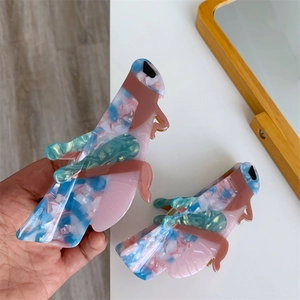 Macro detail of grasshopper hair claw made of pink and blue acetate marble pattern