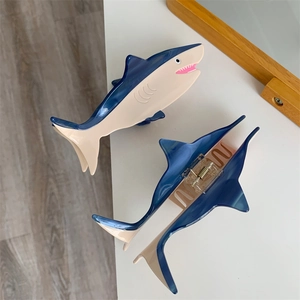 Detail view of navy blue and beige acetate shark hair claw clips for stylish half-up hairstyles