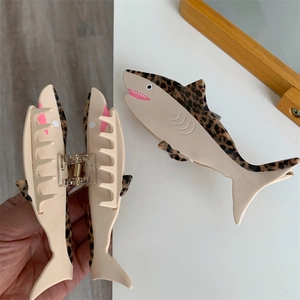 Detailed macro view of the acetate shark hair claw clip with leopard pattern and pink accents
