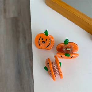 Detalle de pinza para el pelo creativa con forma de calabaza y acabado efecto mármol