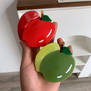 Détail de pinces à cheveux en forme de pommes rouge et verte en acétate brillant
