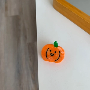 Detalle de pinza para el cabello de calabaza en acetato naranja con sonrisa linda