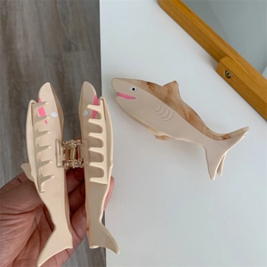 Close-up showing internal spring and claw teeth of marble pattern shark hair clip